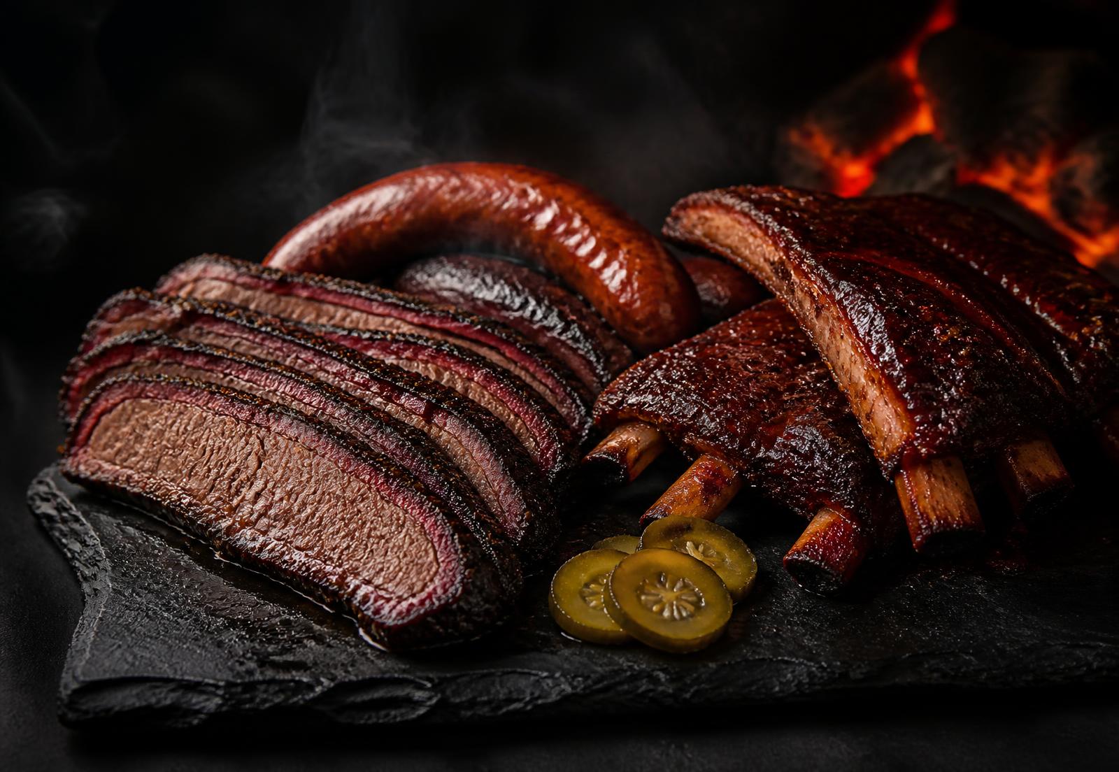 Slow-smoked brisket, ribs and sausage on a slate board